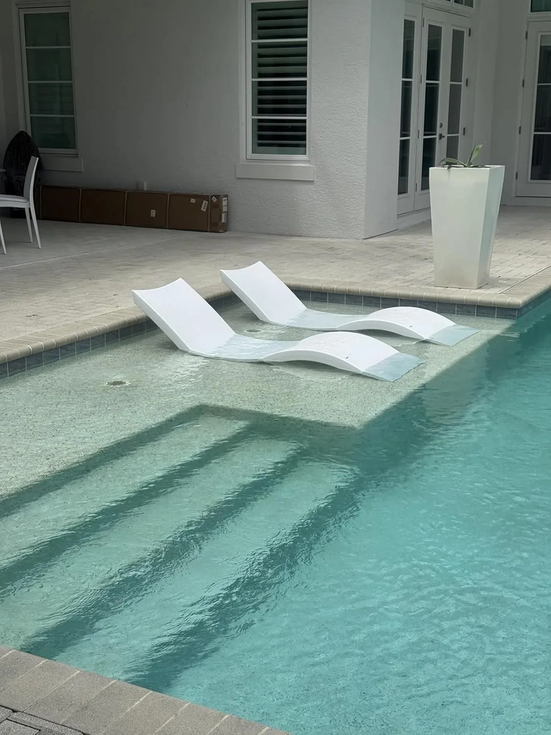 Customer photo of sun shelf installation showing pool deck preparation and positioning