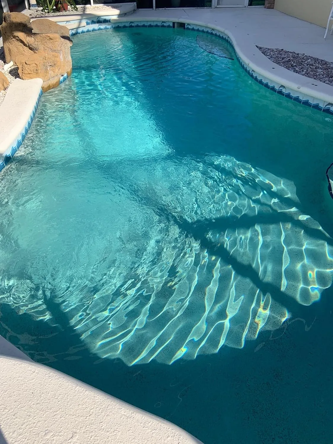 Customer photo of pool water with visible brown metal stains on pool surface after shocking treatment