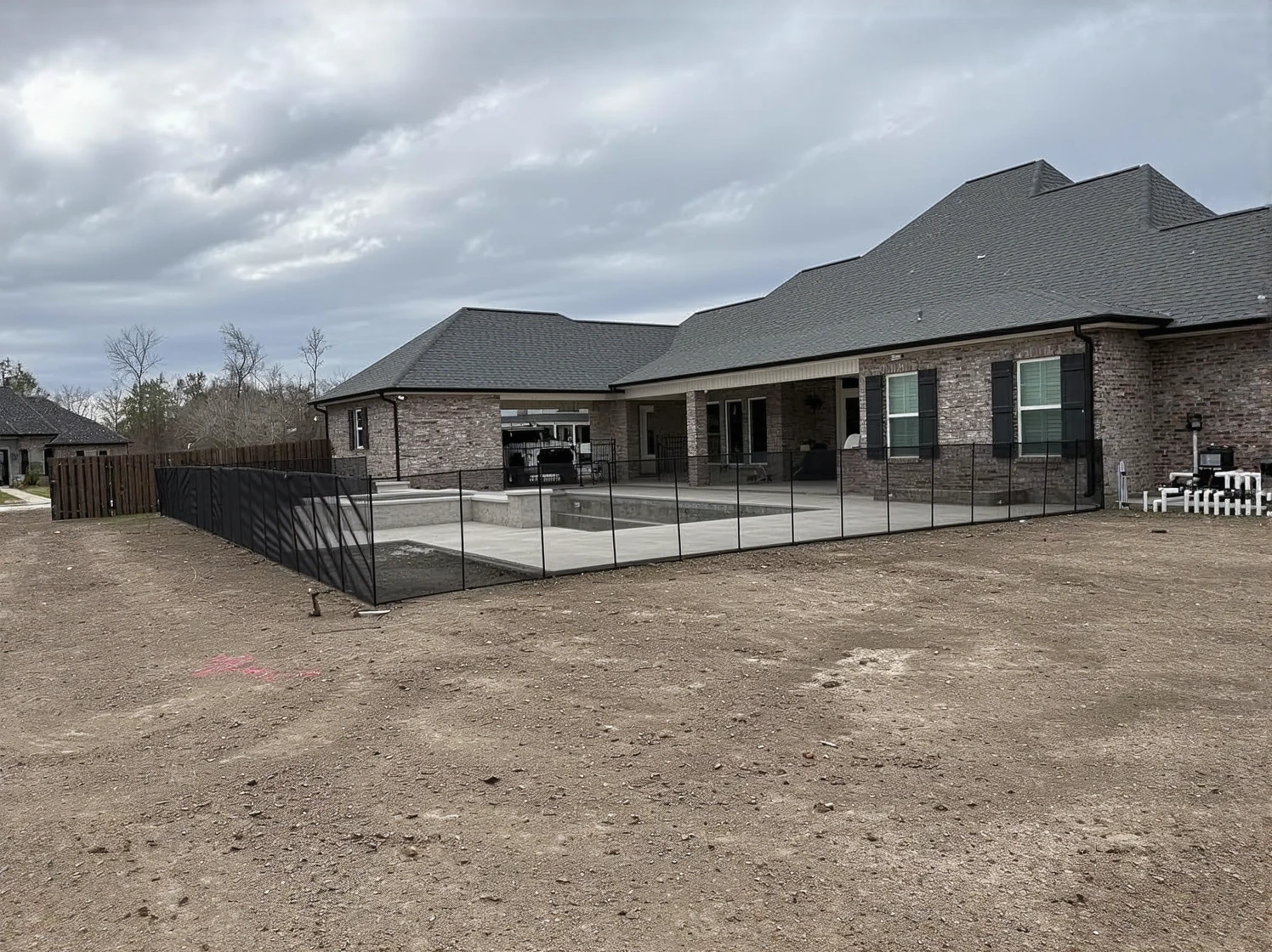 Customer photo of removable pool fencing installed around backyard swimming pool