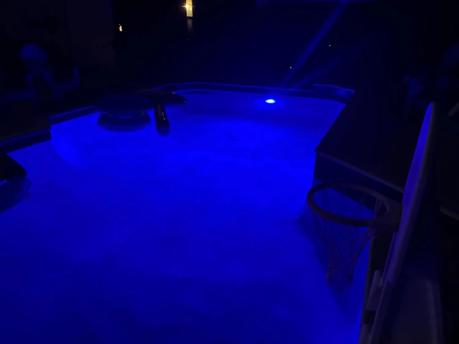Customer photo of underwater LED lights glowing blue in a swimming pool at night