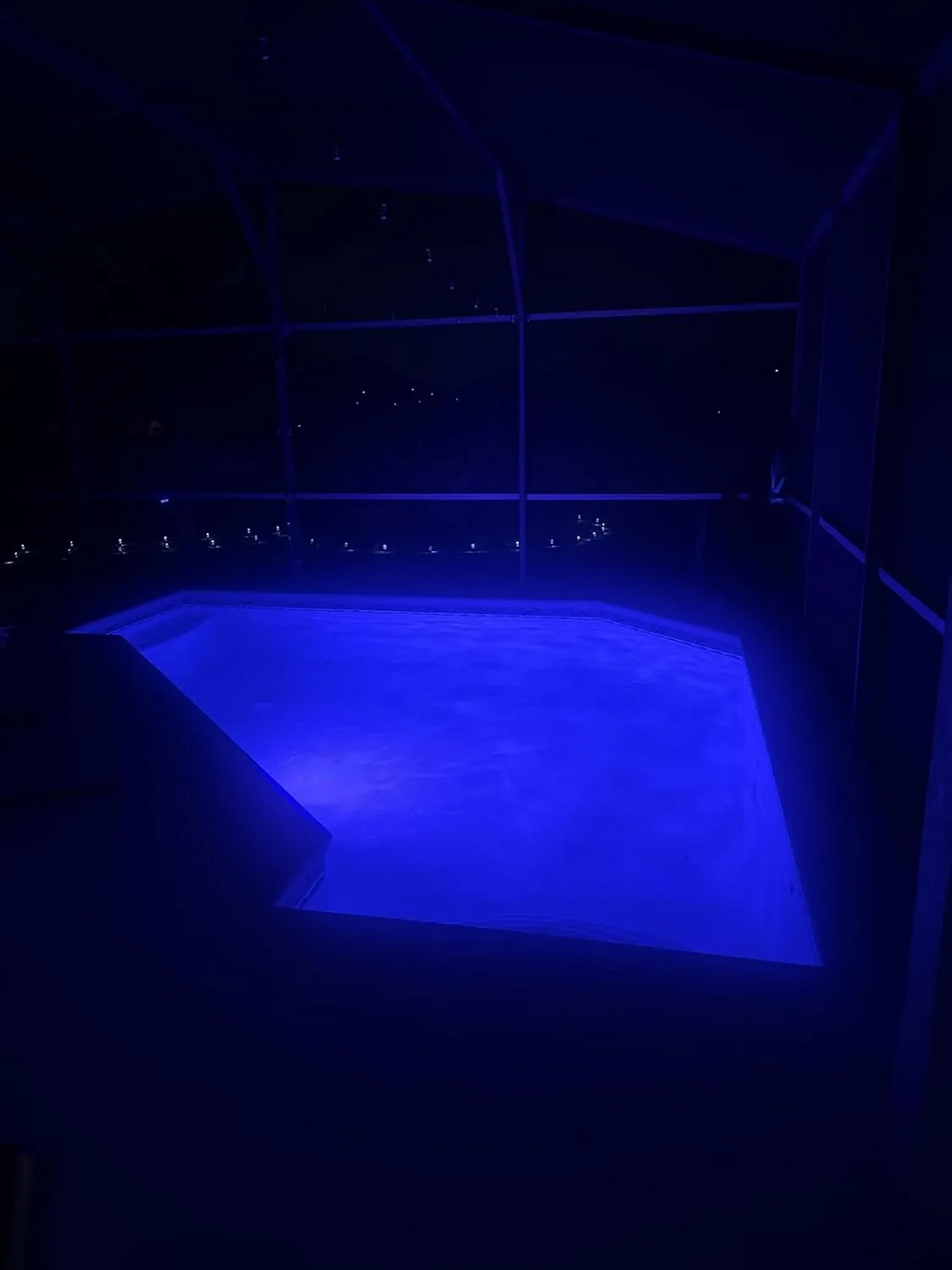 Customer photo of underwater LED lights illuminating a swimming pool at night