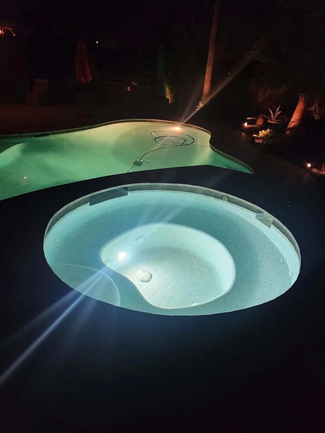 Customer photo of underwater LED lights illuminating pool water at night